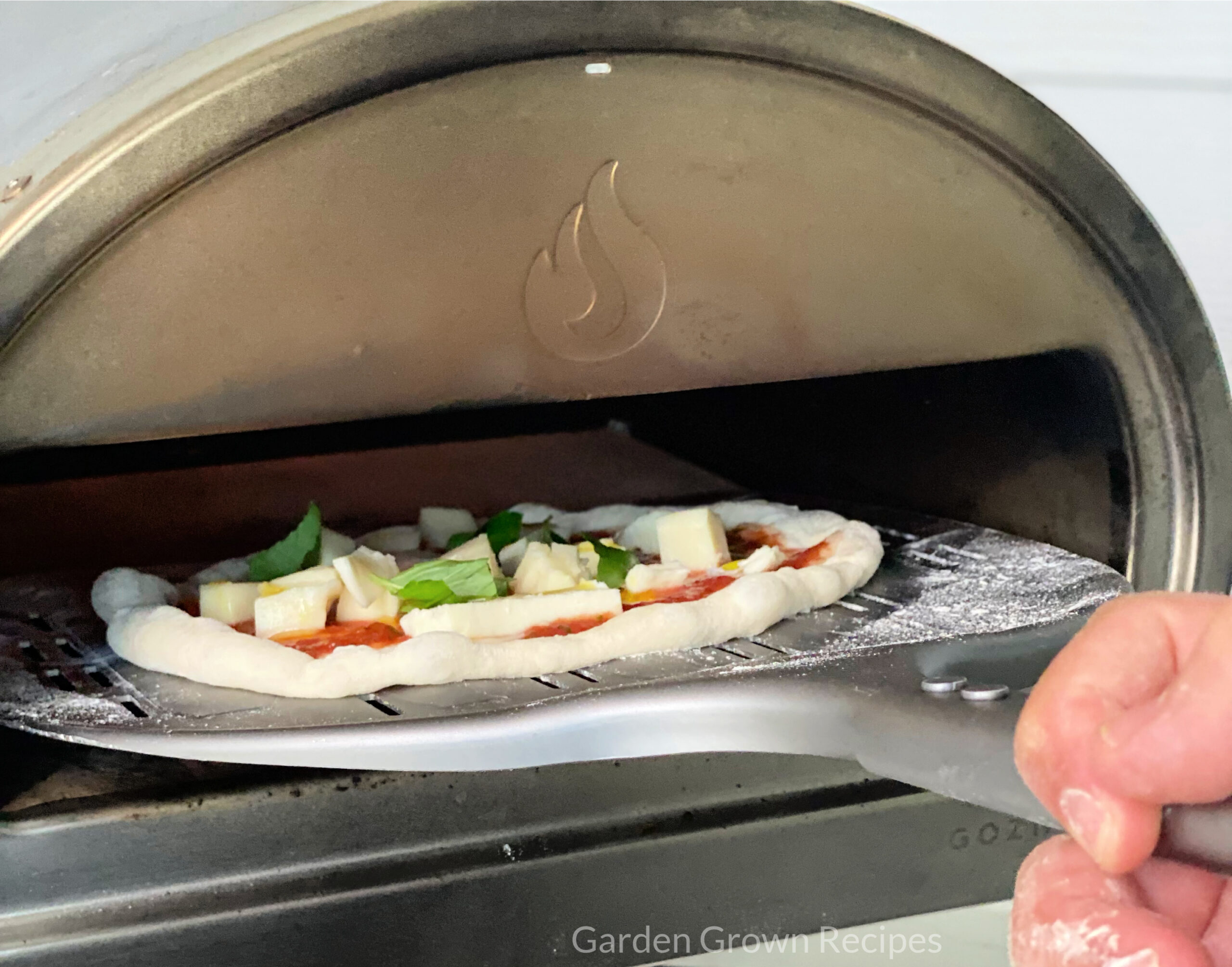 pizza going into pizza oven