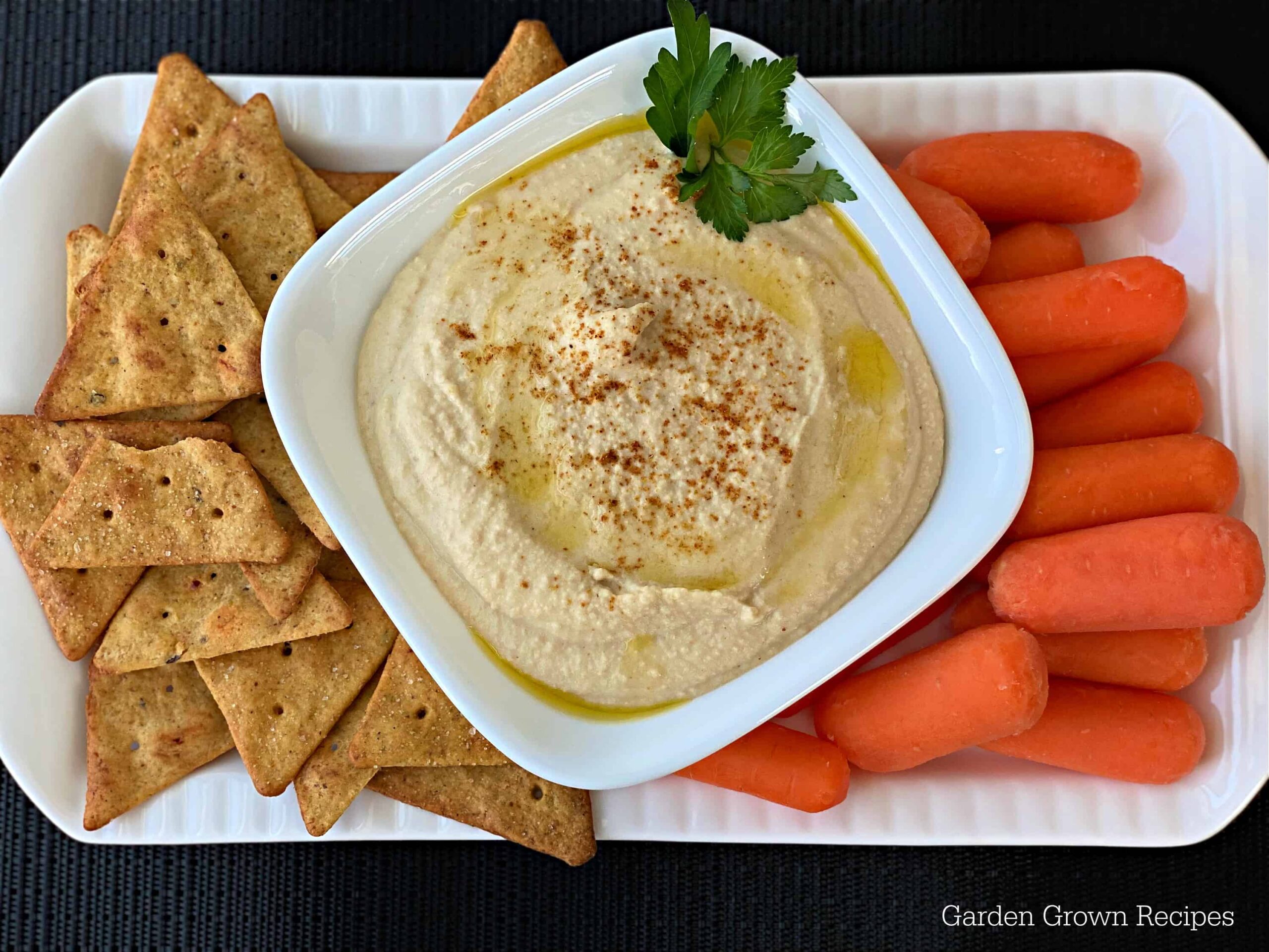 creamy homemade hummus with raw carrots and pita chips