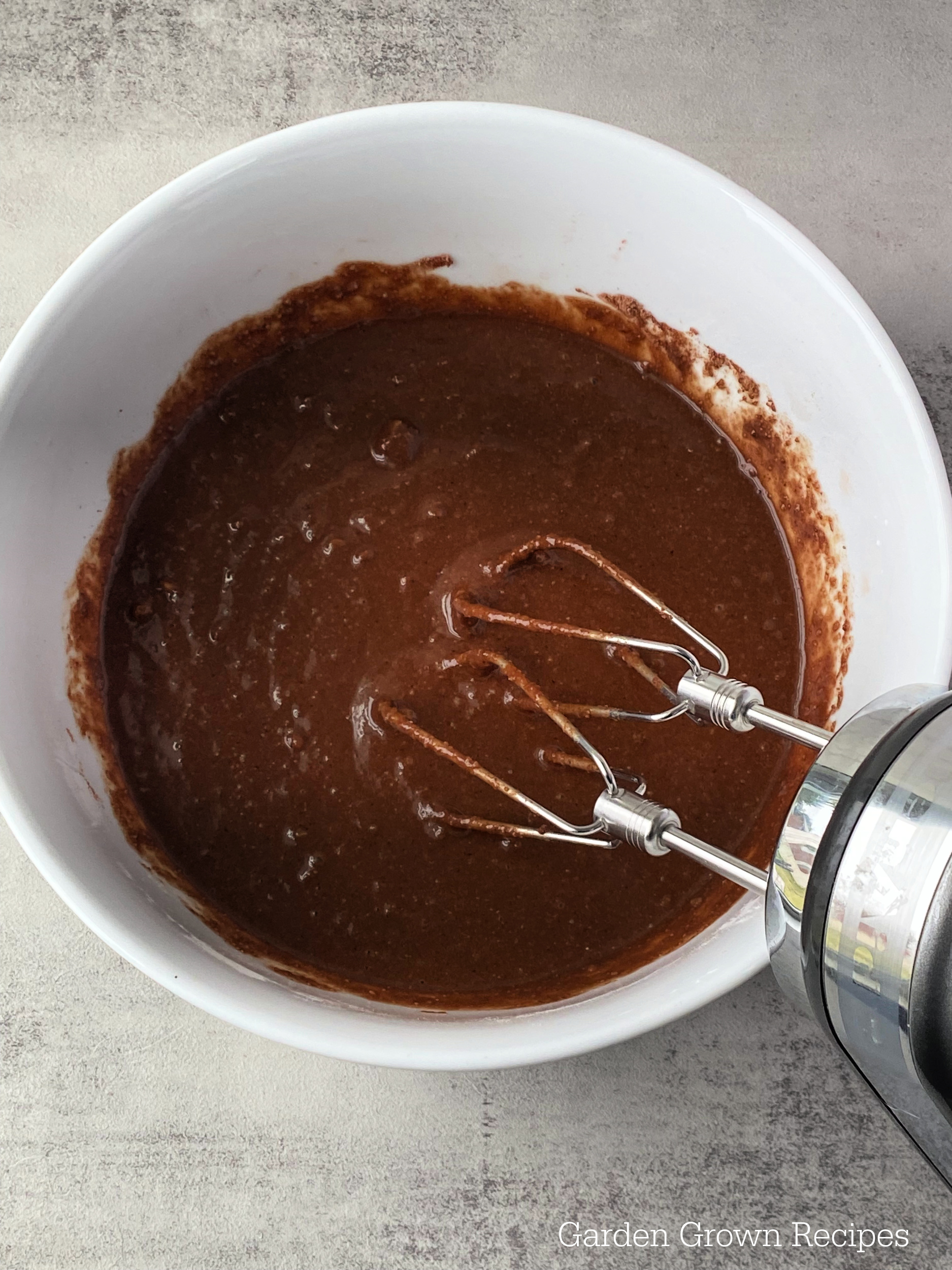 electric mixer in batter to make Baked Chocolate Cake Donut Recipe