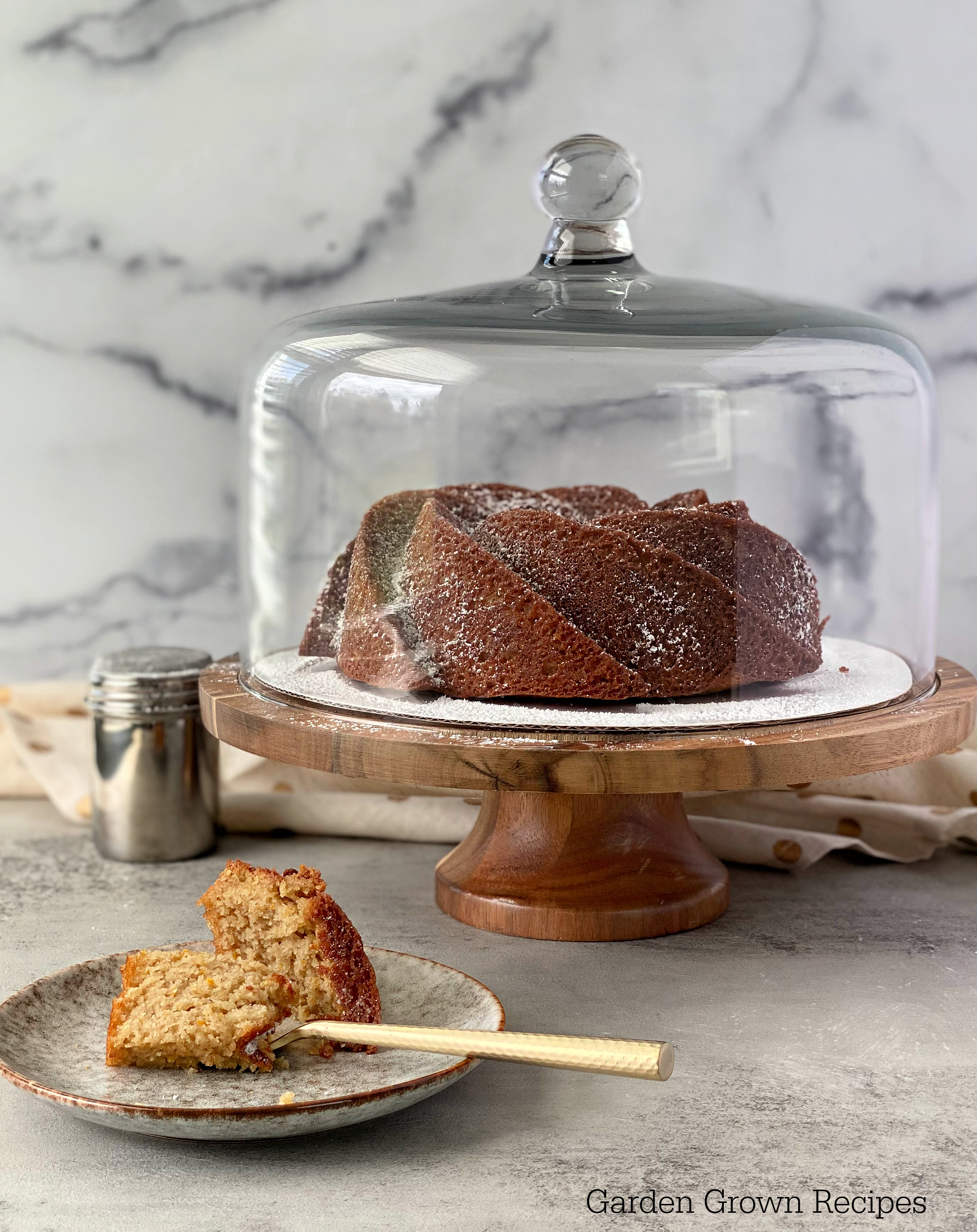 Almond Bundt Cake  on cake stand with glass dome